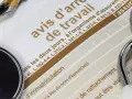 Un stéthoscope et un stylo sur un avis d'arrêt de travail, évoquant une maladie professionnelle pour une aide à domicile.