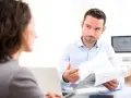 Un homme explique un document à une femme, discutant peut-être de la VAE et de l'obligation employeur.
