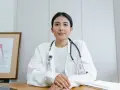 Médecine du travail : ce qu'il ne faut pas dire. Une doctoresse au regard bienveillant, stéthoscope autour du cou, devant un schéma anatomique.