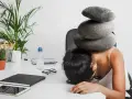 Une femme accablée par des pierres sur la tête, symbolisant le poids du harcèlement au travail. Le référent harcèlement CSE heures de délégation est dépassé.