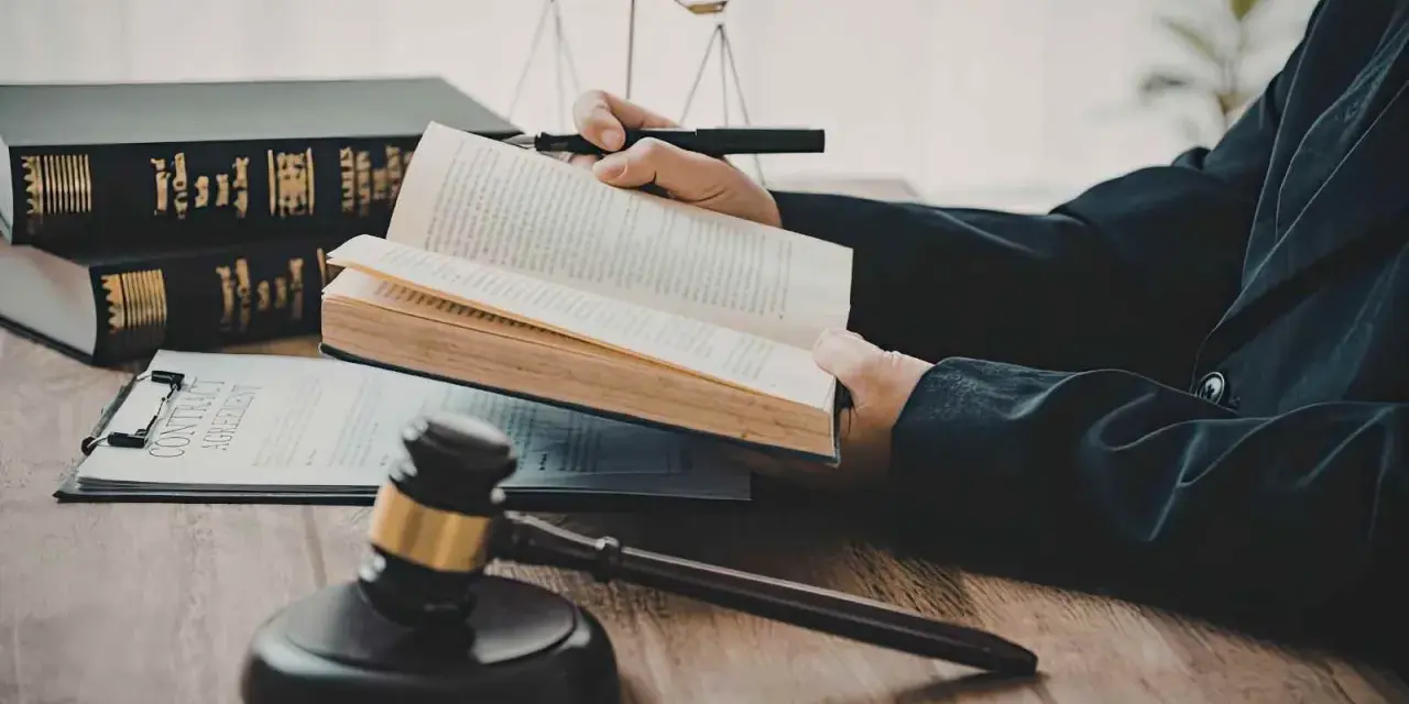 Un avocat étudie le livre de droit, cherchant la définition de l'obligation de résultat selon l'article 1231-1 du Code civil. Balance de la justice et marteau de juge en arrière-plan.