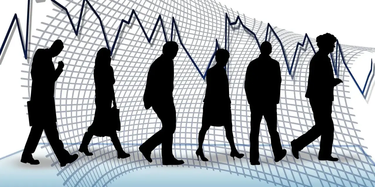 Silhouettes de personnes marchant sur un graphique boursier en baisse, symbolisant un licenciement pour suppression de poste.