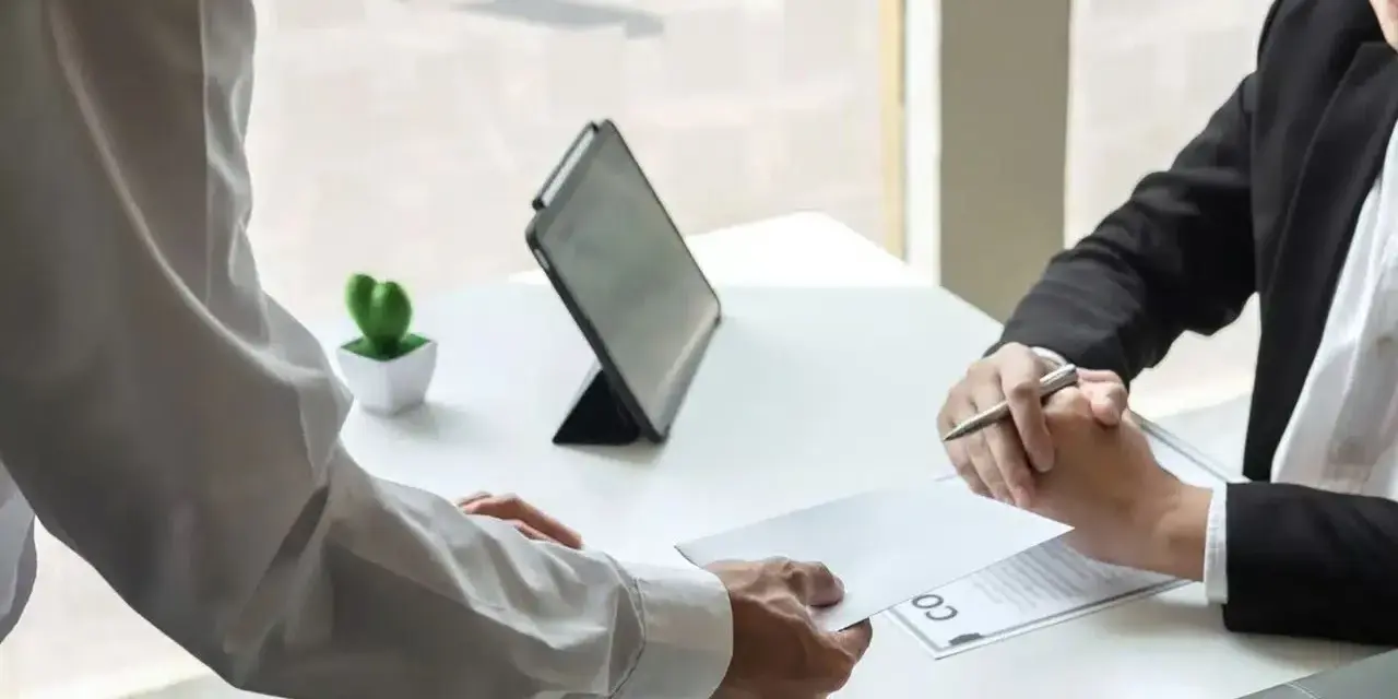 Un employé remet une lettre à son supérieur. Une étape importante pour savoir comment démissionner d'un CSE.