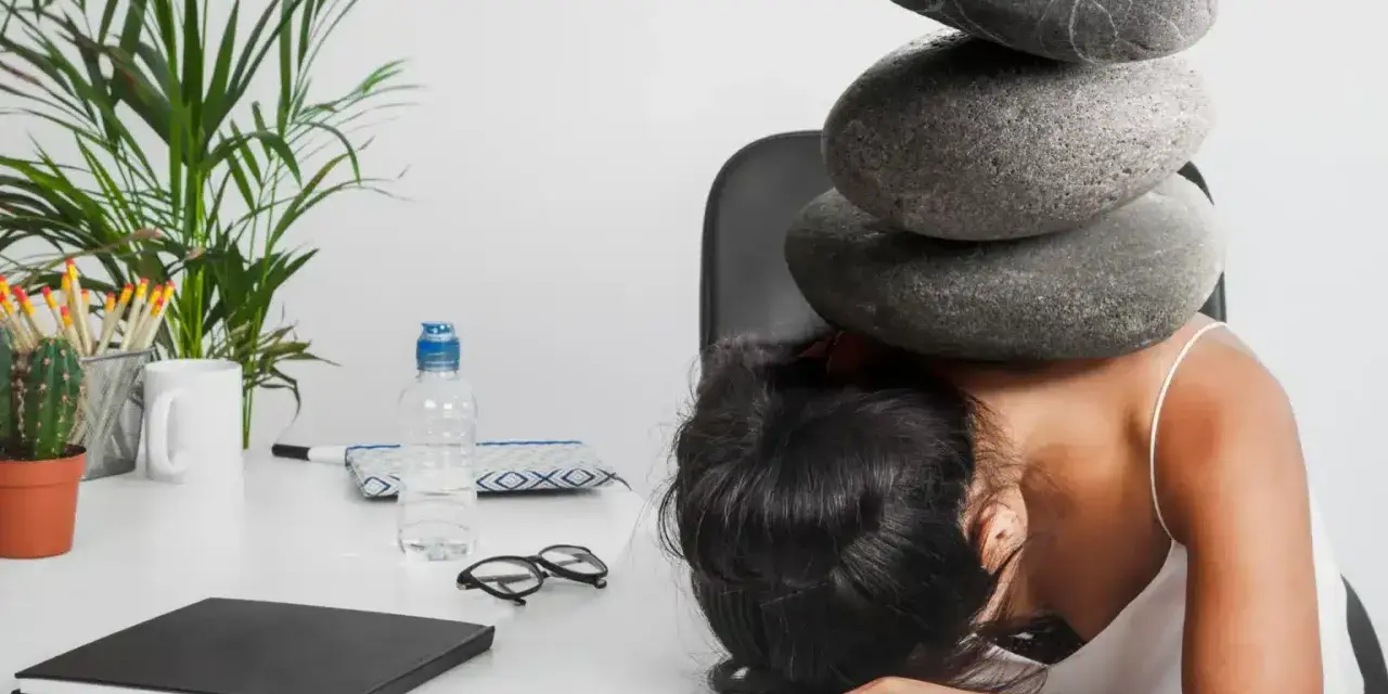 Une femme accablée par des pierres sur la tête, symbolisant le poids du harcèlement au travail. Le référent harcèlement CSE heures de délégation est dépassé.