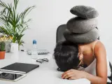 Une femme accablée par des pierres sur la tête, symbolisant le poids du harcèlement au travail. Le référent harcèlement CSE heures de délégation est dépassé.