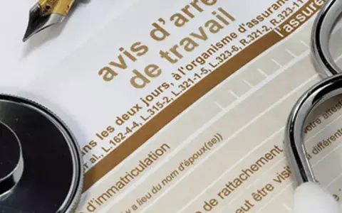 Un stéthoscope et un stylo sur un avis d'arrêt de travail, évoquant une maladie professionnelle pour une aide à domicile.