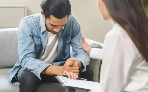 Un homme en arrêt maladie psychiatre reçoit un soutien réconfortant d'une thérapeute lors d'un contrôle.