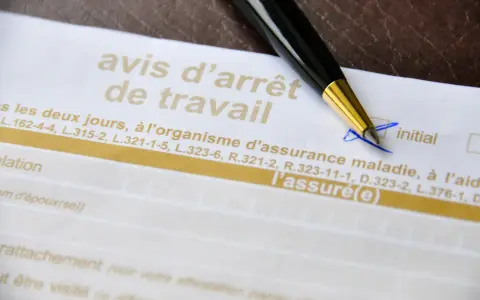 Un stylo sur un avis d'arrêt de travail, un document officiel pour justifier une absence.