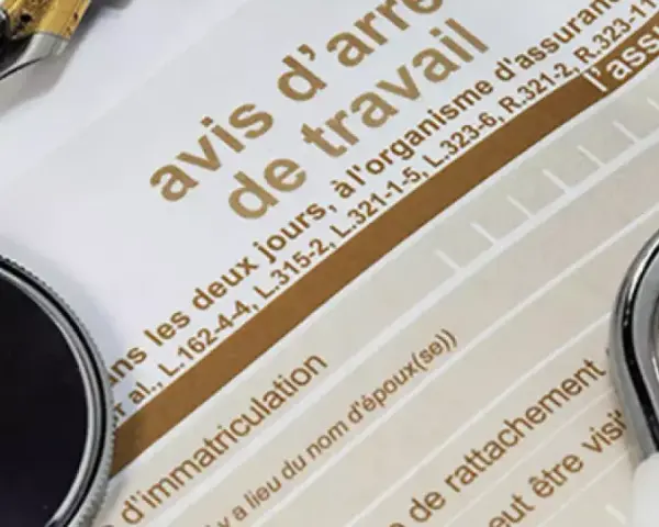 Un stéthoscope et un stylo sur un avis d'arrêt de travail, évoquant une maladie professionnelle pour une aide à domicile.