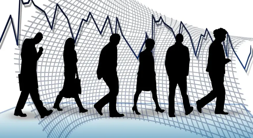 Silhouettes de personnes marchant sur un graphique boursier en baisse, symbolisant un licenciement pour suppression de poste.