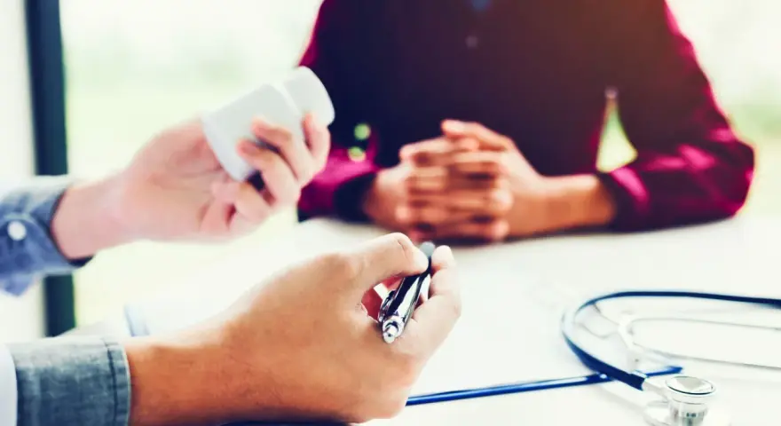 Un médecin donne des médicaments à un patient lors d'une visite de reprise obligatoire.