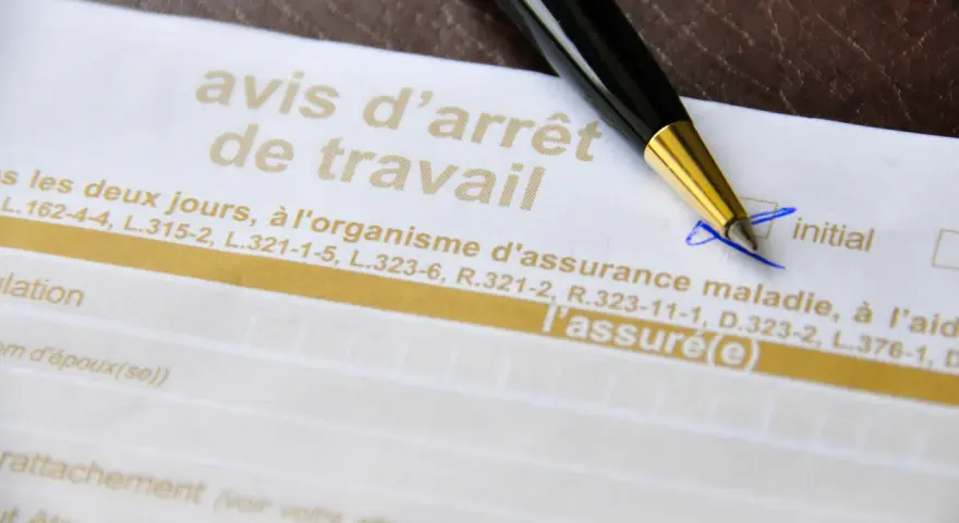 Un stylo sur un avis d'arrêt de travail, un document officiel pour justifier une absence.