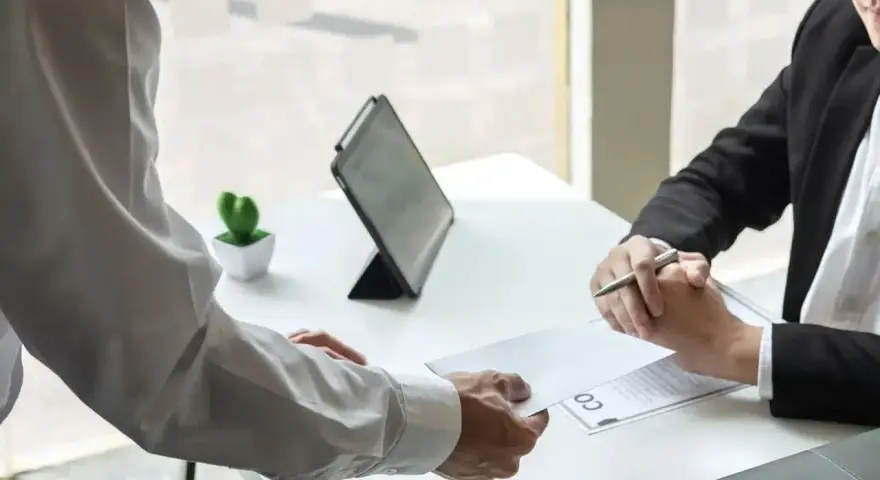 Un employé remet une lettre à son supérieur. Une étape importante pour savoir comment démissionner d'un CSE.