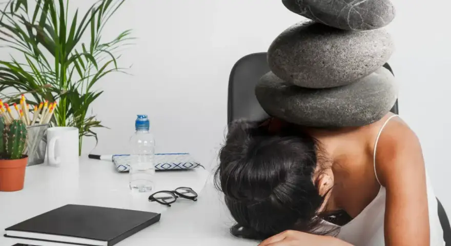 Une femme accablée par des pierres sur la tête, symbolisant le poids du harcèlement au travail. Le référent harcèlement CSE heures de délégation est dépassé.