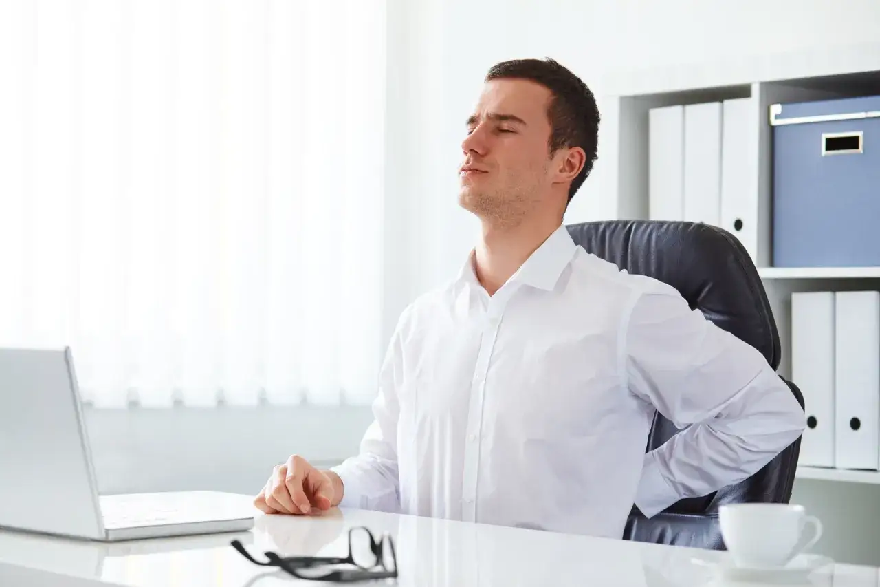 Homme souffrant du dos à son bureau, mon employeur refuse mon aménagement de poste.